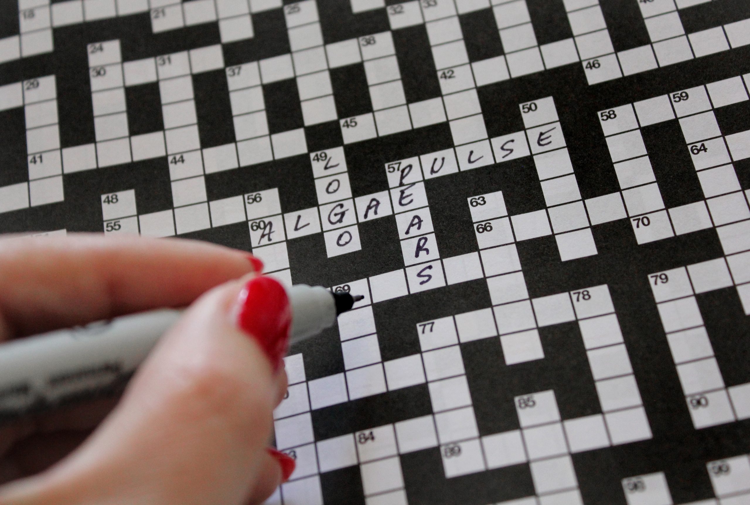 hand holding a pen doing a crossword puzzle 2025 01 09 12 26 49 utc scaled