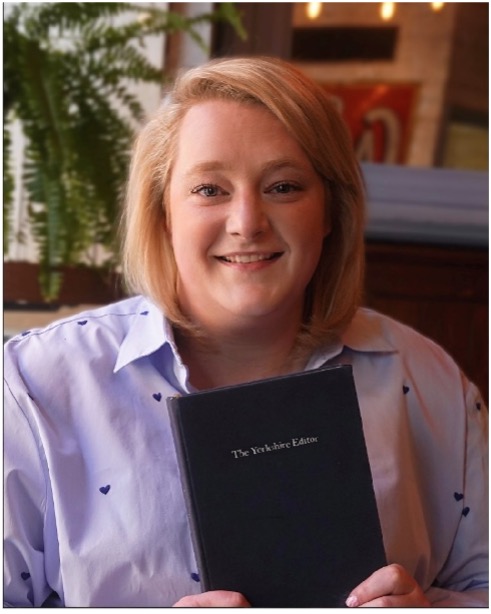Katie holding a TYE Book